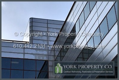 Company cleaning caulking stained stainless steel facade panels.