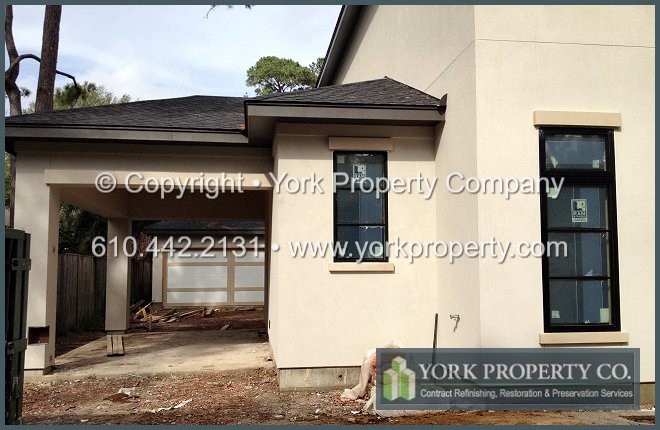 Stucco splatter stained metal window frame construction cleaning.