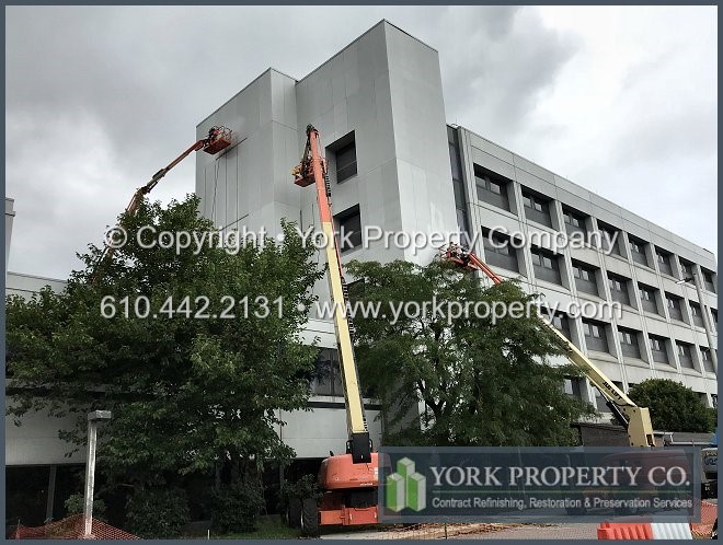 Washing old dirty stained anodized aluminum exterior facade paneling.